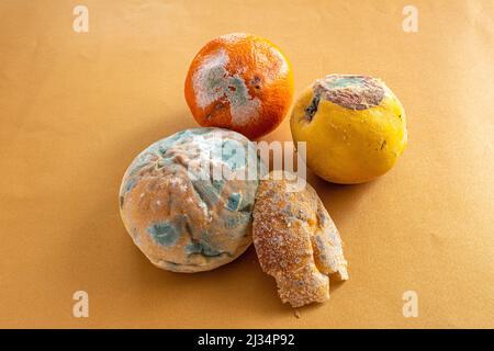 Aliments mouleurs. Vue de dessus du pain pourri, de l'orange et du coing sur fond de couleur. Pain et fruits couverts de moisissure. Concept de gaspillage de nourriture. Banque D'Images