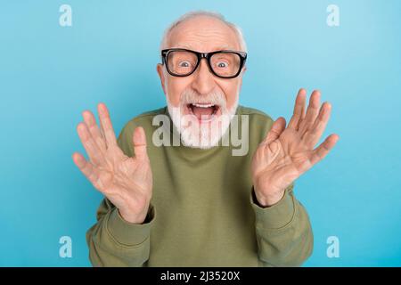 Portrait de l'attrayant stupéfié gai fou gris-cheveux homme ayant le plaisir isolé sur fond bleu clair de couleur Banque D'Images