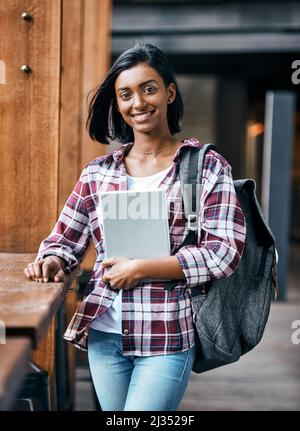 Je suis fier d'apprendre ici et prêt à apprendre. Portrait d'une jeune étudiante tenant une tablette à l'extérieur du campus. Banque D'Images