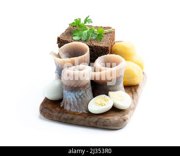 Rouleau de hareng mariné maison avec pain de seigle et petite pomme de terre avec œufs de quial isolés en blanc Banque D'Images