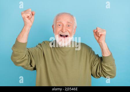 Portrait de l'homme joyeux gris-cheveux attrayant se réjouissant d'avoir plaisir grand succès isolé sur fond bleu clair de couleur Banque D'Images