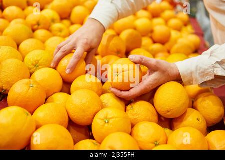 Client au stand de fruits et légumes dans le supermarché pour acheter des oranges Banque D'Images