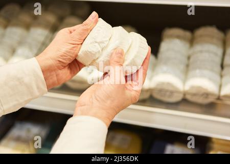 Les clients magasinent dans le supermarché à l'étagère réfrigérée avec du fromage doux de la production régionale Banque D'Images