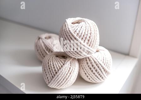 bobines de couleur pastel beige clair pour tisser des aiguilles en forme de macrame sur un fond clair Banque D'Images