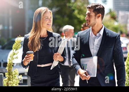 Des millions de personnes en déplacement. Photo de collègues d'entreprise ayant une discussion en marchant dans la rue. Banque D'Images