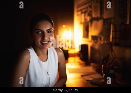 Il n'est jamais trop tard pour parvenir à plus de succès. Portrait d'une jeune femme d'affaires travaillant tard dans un bureau. Banque D'Images