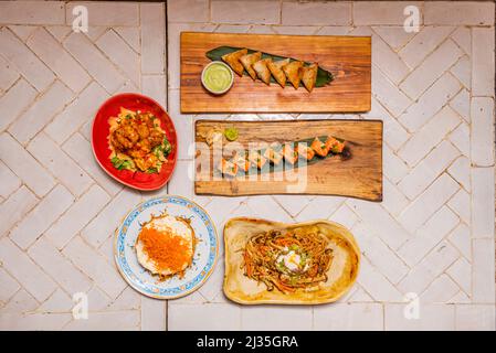Menu de sushis varié avec nigiri, saumon norvégien, rouleau de californie uramaki, riz blanc, algues nori, wasabi, gingembre, gâteau aux carottes, nouilles frites avec chis Banque D'Images