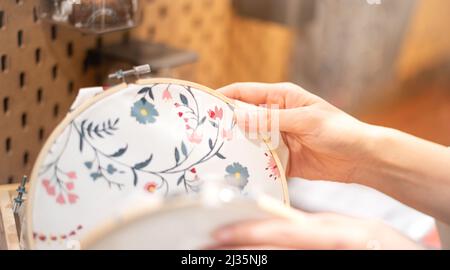 Femme main choisir le cadre de broderie de bois avec le motif de couture dans un processus de handiwork. Le week-end, profitez de votre temps libre. Banque D'Images