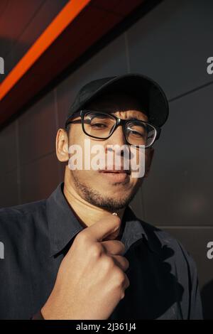 Un jeune homme afro-américain mange des arachides sur fond noir Banque D'Images