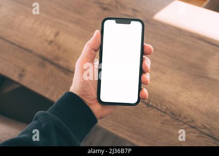Un smartphone avec une main masculine dans l'intérieur de la maison, mise au point sélective Banque D'Images
