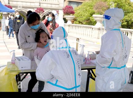 (220406) -- SHANGHAI, le 6 avril 2022 (Xinhua) -- des travailleurs médicaux de la province de Hainan prélèvent des échantillons d'écouvillons de résidents pour des tests d'acide nucléique dans une communauté du district de Jiading de Shanghai, en Chine orientale, le 6 avril 2022. Selon les autorités locales, Shanghai a lancé mercredi une nouvelle série de tests d'antigène et d'acide nucléique à l'échelle de la ville, dans le cadre des efforts visant à contenir la résurgence récente des cas de COVID-19 dans la métropole. La décision a été prise sur la base des résultats des tests de masse des acides nucléiques de lundi, selon le groupe municipal de pointe de Shanghai pour la prévention et le contrôle de la COVID-19. (Xinhua Banque D'Images