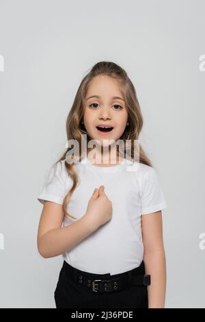 fille stupéfait dans un t-shirt blanc pointant avec le doigt sur elle-même isolée sur gris Banque D'Images