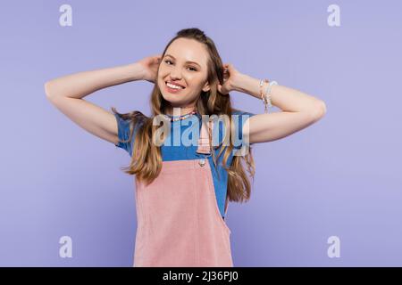 portrait de la femme heureuse en robe générale isolée sur le violet Banque D'Images