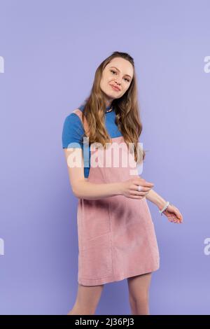 portrait d'une femme souriante en robe générale isolée sur le violet Banque D'Images
