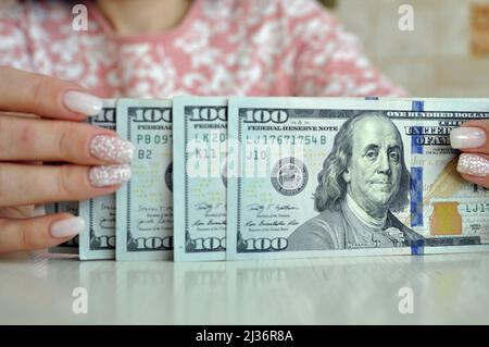 Les mains des femmes comptent des dollars en espèces. 1000 dollars en 100 billets de gros plan. Crise financière. Banque D'Images