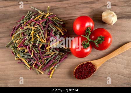 Nouilles traditionnelles turques avec tomate, ail et poivre sur fond de bois Banque D'Images
