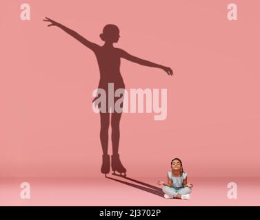 Petite fille heureuse assise sur le sol et rêvant de devenir patineuse de figure isolée sur fond rose. Sport, carrière et rêve. Collage Banque D'Images