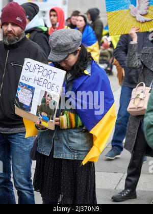 Nous avons baduré le démonstrateur féminin avec LE SOUTIEN DE NOS HÉROS écriteau avec des photos du président Zelensky et une BANNIÈRE DE NON-GUERRE Banque D'Images