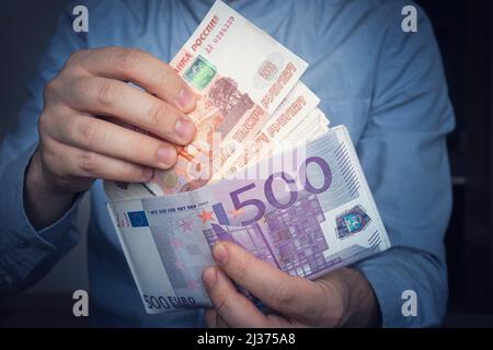 Les mains sortent les roubles russes du portefeuille. Gros plan sur les mains d'un homme comme il obtient un billet de banque de son portefeuille. Beaucoup d'argent. Un homme riche. Revenu Banque D'Images