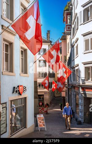 Centre historique de la ville de Zurich avec Swiss drapeaux suspendus bâtiments avec effet de flou sur l'arrière-plan flou d'une journée ensoleillée en été, Suisse Banque D'Images