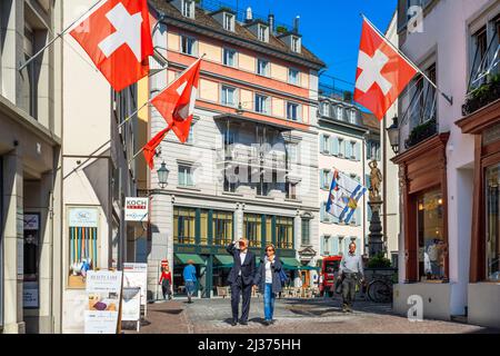 Centre historique de la ville de Zurich avec Swiss drapeaux suspendus bâtiments avec effet de flou sur l'arrière-plan flou d'une journée ensoleillée en été, Suisse Banque D'Images