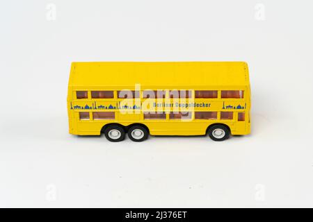 Miniature jaune tporist grand bus isolé sur fond blanc, double decker métal bus mini jouet vue avant, angle incliné objet Banque D'Images