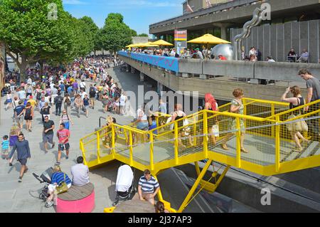 Visiteurs et touristes sous le soleil d'été sur la promenade au bord de la rivière au Southbank Center, un complexe de lieux de divertissement et d'art à Lambeth, Londres, Royaume-Uni Banque D'Images