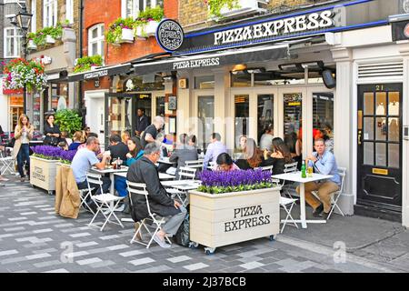 Les clients s'assoient à l'extérieur du restaurant Pizza Express pour manger à l'extérieur et dîner en plein air dans la rue St Christophers place libre de la circulation, à proximité d'Oxford Street London West End UK Banque D'Images