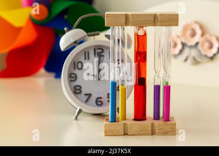 Sablier décoratif à mise au point sélective. Radio-réveil classique hors foyer caché derrière le sablier. L'horloge indique 12 heures. Banque D'Images