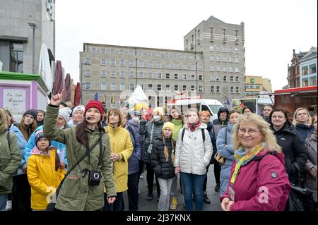 06 avril 2022, Saxe-Anhalt, Halle (Saale): Le guide Beate Krauße (r) et l'interprète Roksolana Grabko (l) dirigent les réfugiés d'Ukraine à travers la ville. En plus des points pertinents tels que le bâtiment de l'administration de la ville, ils introduisent également des possibilités de shopping, des installations gastronomiques et de musée et des points touristiques sélectionnés dans le centre-ville et la vieille ville. Photo: Heiko Rebsch/dpa Banque D'Images