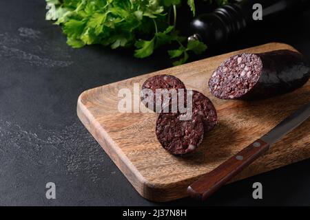 Morcilla de saucisse de sang servie sur un plateau en bois sur fond noir avec espace de copie. Gros plan. Cuisine coréenne. Banque D'Images