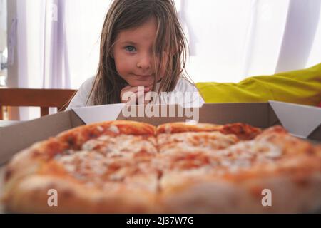 Une fille mange de la pizza, de la nourriture pour bébés, de la restauration rapide. Photo de haute qualité Banque D'Images