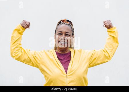 Femme africaine senior faisant de l'exercice de routine d'entraînement en extérieur - Focus sur le visage Banque D'Images