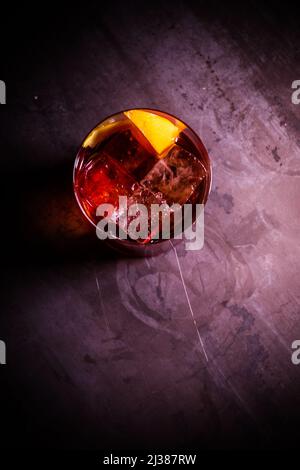 Une vue de dessus, un cocktail alcoolique exotique rose avec citron et glace sur la table du bar avec éclairage Banque D'Images
