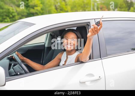 femme noire pilote assis dans sa nouvelle voiture Banque D'Images