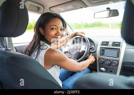 femme noire pilote assis dans sa nouvelle voiture Banque D'Images