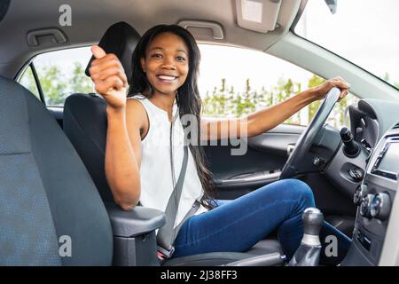 femme noire pilote assis dans sa nouvelle voiture Banque D'Images