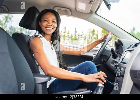 femme noire pilote assis dans sa nouvelle voiture Banque D'Images