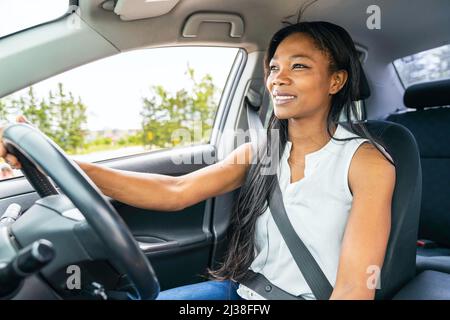 femme noire pilote assis dans sa nouvelle voiture Banque D'Images