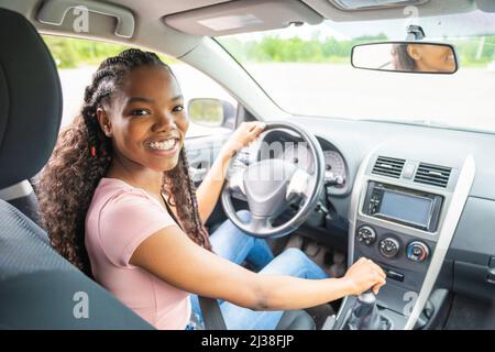 Jeune chauffeur adolescent noir assis dans sa nouvelle voiture Banque D'Images