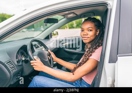 Jeune chauffeur adolescent noir assis dans sa nouvelle voiture Banque D'Images