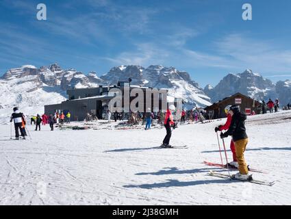 Vacances de ski; skieurs approchant du restaurant Chalet Fiat sur les pistes de ski en vacances de ski, Madonna do Campiglio, Dolomites Italie Europe Banque D'Images