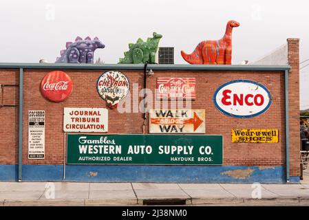 Des panneaux vintage sur un mur de briques rouges et des dinosaures sur le toit de Sparky’s, un restaurant populaire et une attraction de bord de route et à Hatch, au Nouveau-Mexique. Banque D'Images