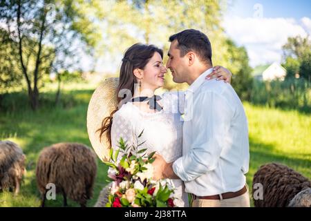 un couple de mariage d'amoureux, la mariée et le marié, sont debout au milieu de belles collines vertes. Banque D'Images