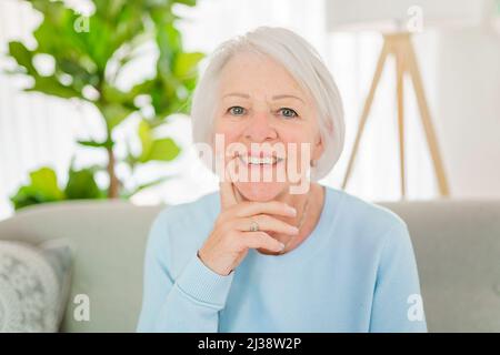 portrait de femme âgée assis sur le canapé à la maison Banque D'Images