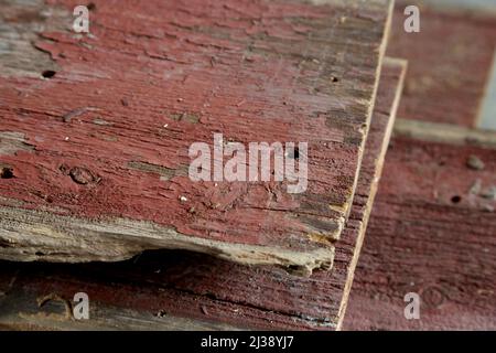 Gros plan d'une pile de panneaux rouges abîmés récupérés d'une ancienne grange. Banque D'Images
