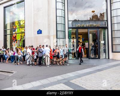 PARIS, FRANCE - 12 JUIN 2015 : les gens font la queue devant la boutique Louis Vuitton aux champs-élysées pour faire du shopping. Banque D'Images