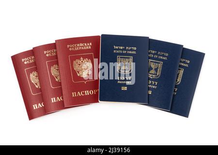 Pile de passeports de voyage internationaux israéliens et russes isolés sur fond blanc. Banque D'Images