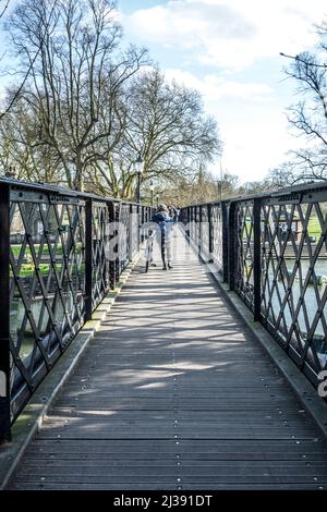 CAMBRIDGE, ANGLETERRE - 13 MARS 2017 : personnes traversant la came de la rivière à un vieux pont piétonnier en fer. Banque D'Images