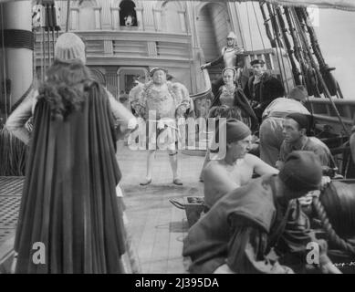 "Jeune Bess" comme le Père, comme la fille: Bess (Jean Simmons) frappe une posture têtue comme celle de son père, Henry VIII (Charles Laughton), à bord du navire amiral du roi, le Grand Harry, alors qu'elle défie ouvertement sa colère contre la nouvelle reine Catherine Parr. Catharine (Deborah Kerr), Ned Seymour (Guy Rolfe) et Tom Seymour (Stewart Granger, sur les pas), la regardent admirablement, mais craignent pour sa vie. 22 juin 1953. (Photo de MGM). Banque D'Images